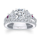 A white gold ring with a round central diamond, marquise and round pink sapphire accents, and a matching wedding band.