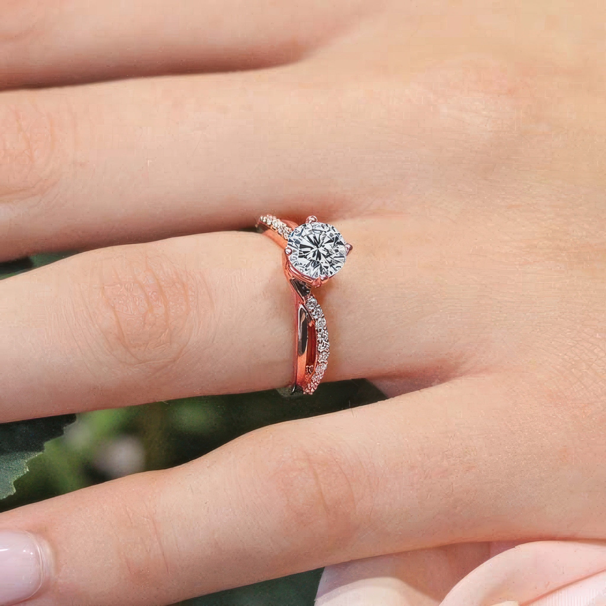 Close-up of a hand wearing a Twisted Engagement Ring with a round center stone and sparkling accent stones.
