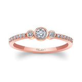 Mia Three Stone Diamond Promise Ring featuring a bezel set center diamond and shared prong set diamonds on a rose gold band.