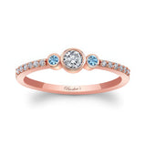 Mia Three Stone Aquamarine Accent Diamond Promise Ring with a diamond center and aquamarine side stones on rose gold band.