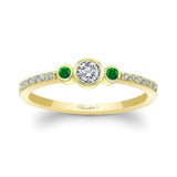 Mia Three Stone Emerald Accent Diamond Promise Ring featuring a bezel set diamond and emerald side stones in yellow gold.