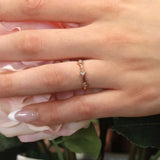 Mila three stone princess cut promise ring displayed on hand with flowers, perfect for meaningful moments.