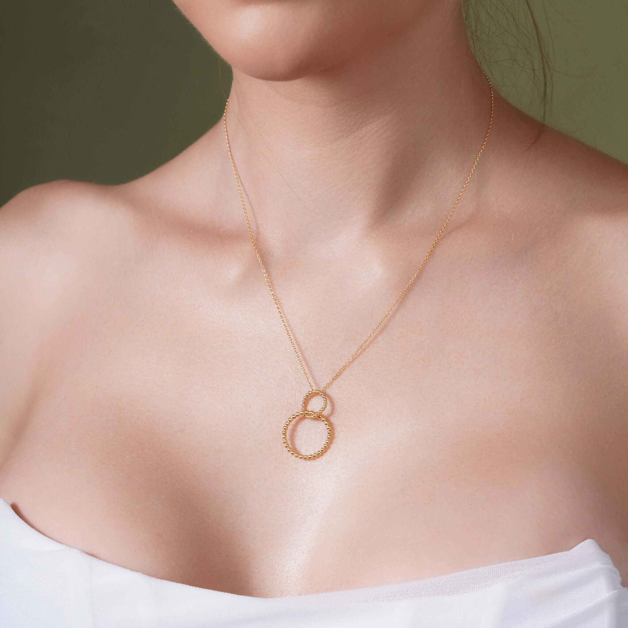 Double Beaded Circle Necklace worn on a model showcasing its elegant design in gold.