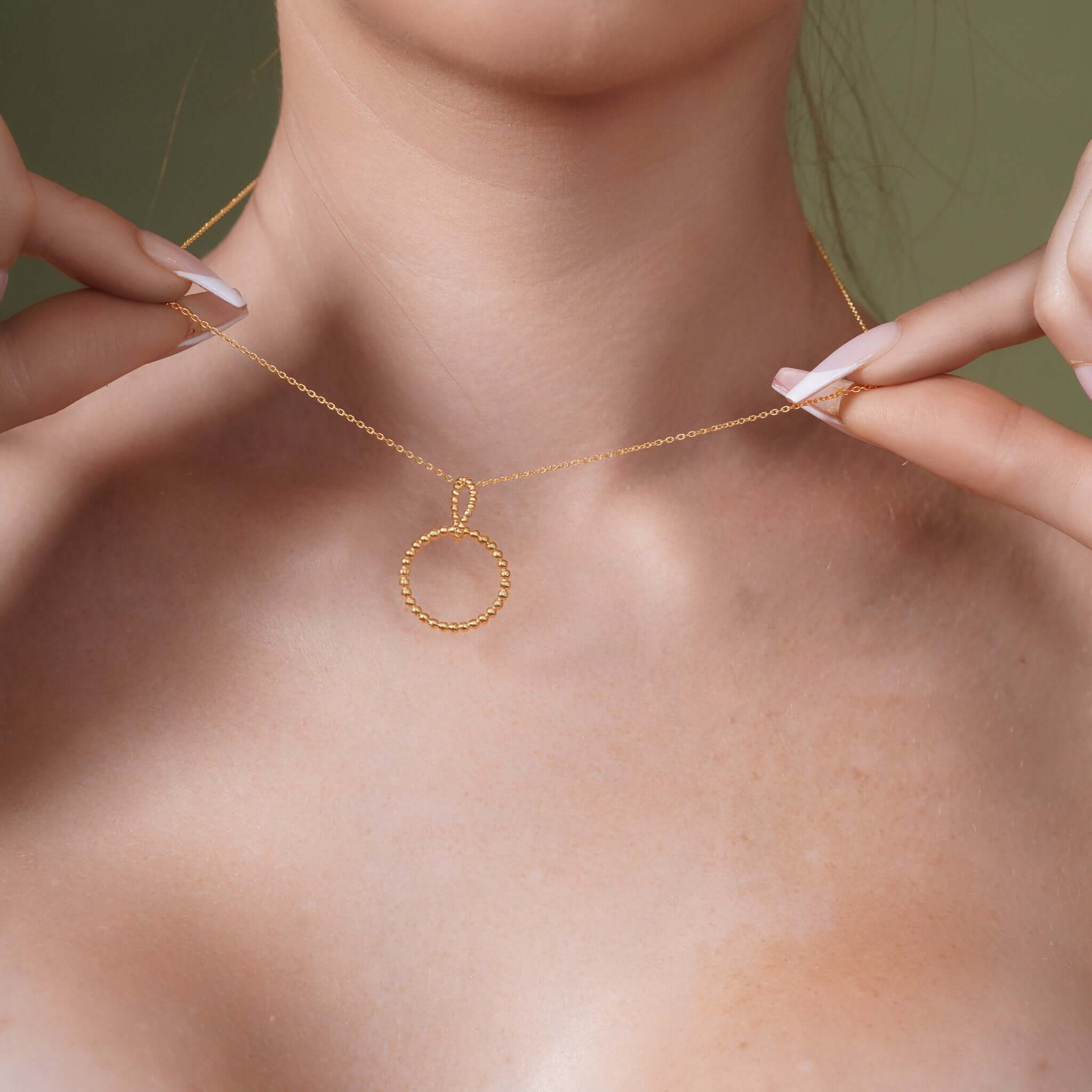Double Beaded Circle Necklace showcasing a gold beaded circle pendant worn by a model.