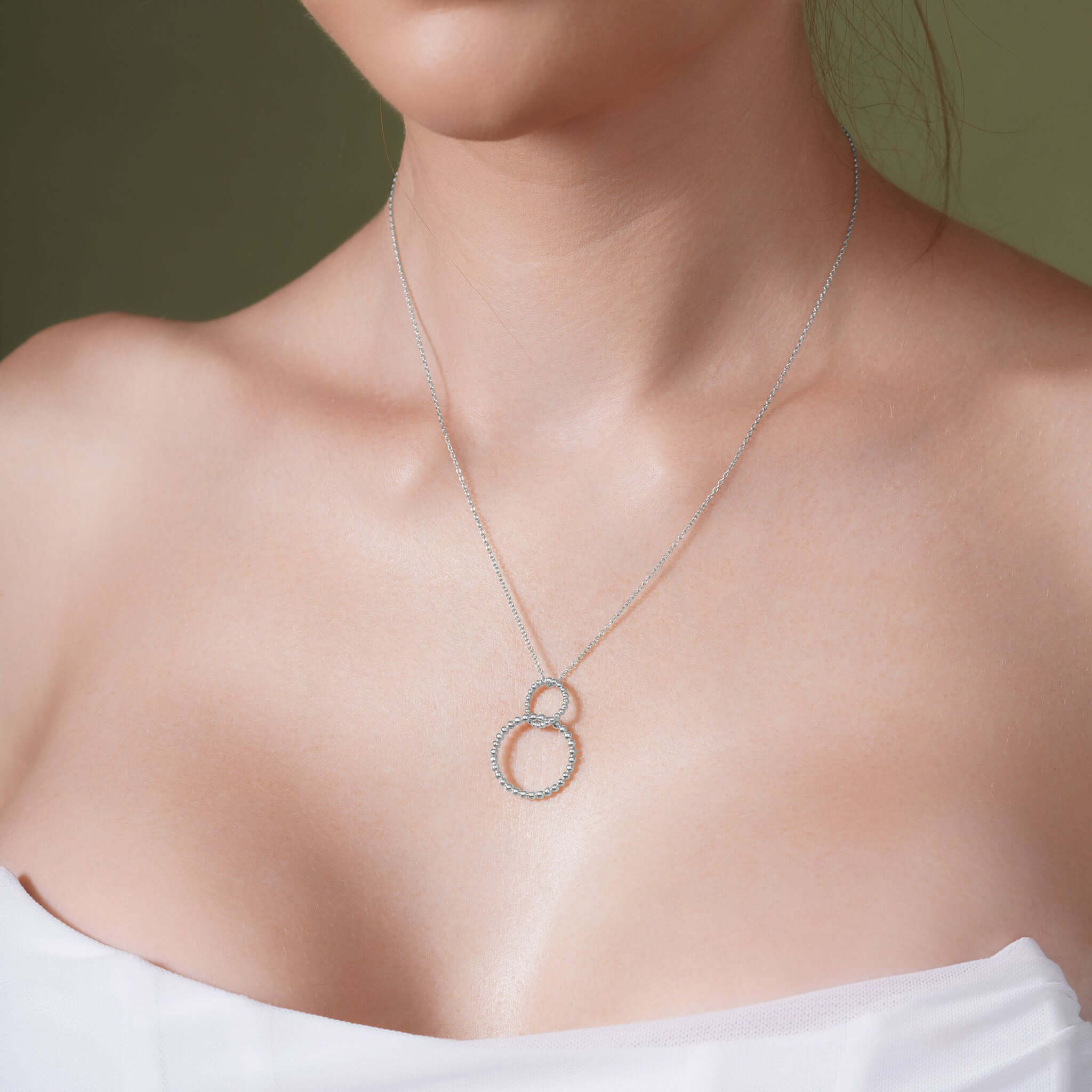 Double Beaded Circle Necklace elegantly displayed on a model, showcasing intertwined circles in 14k white gold.
