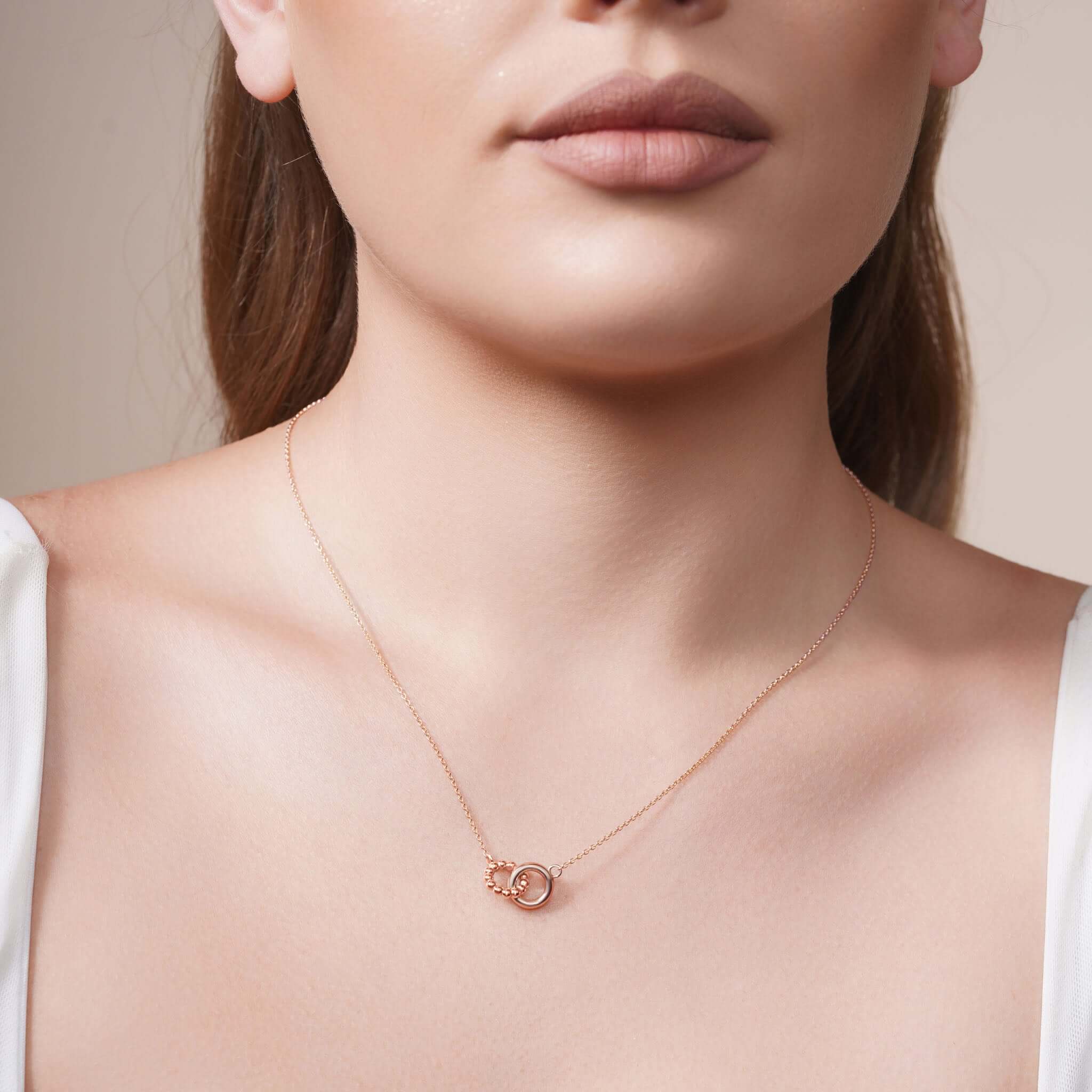 Gold Double Circle Necklace worn elegantly on a model, showcasing intertwined circles and delicate design.