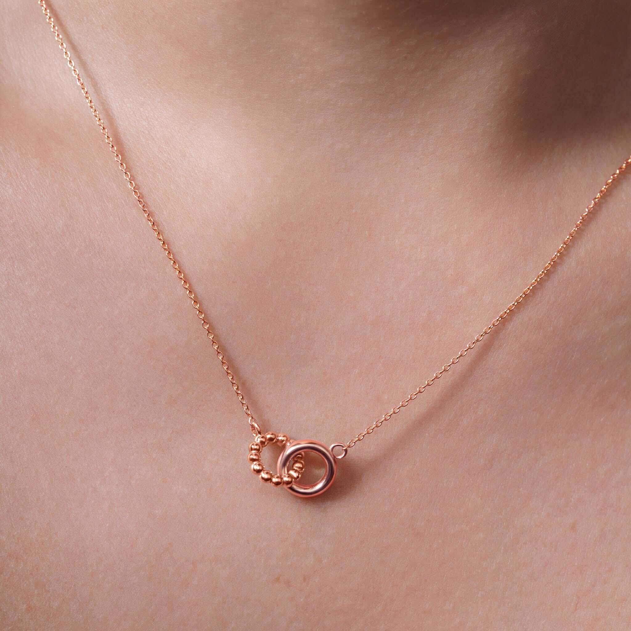 Elegant Gold Double Circle Necklace featuring intertwined circles and delicate beading, perfect for any outfit.