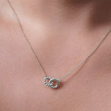 Gold Double Circle Necklace showcasing intertwined circles on a delicate chain, highlighting elegance and versatility.