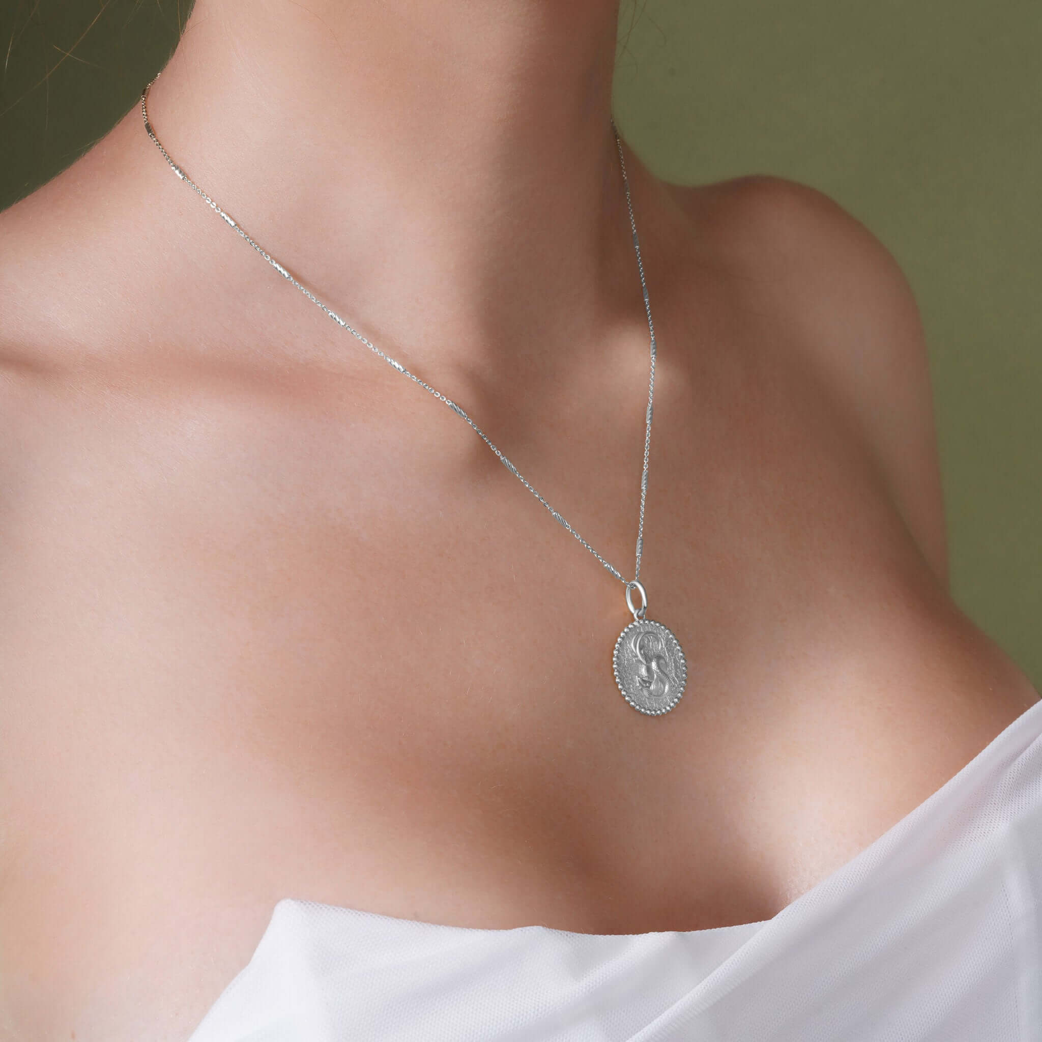 Zodiac Necklace showcasing a medallion design with a zodiac symbol on a sleek silver chain.