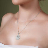 Zodiac Necklace worn on a model's neck, showing the zodiac medallion against a textured background.