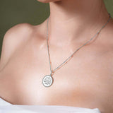 Zodiac Necklace worn close to the neckline, showcasing a zodiac symbol medallion with a textured background.