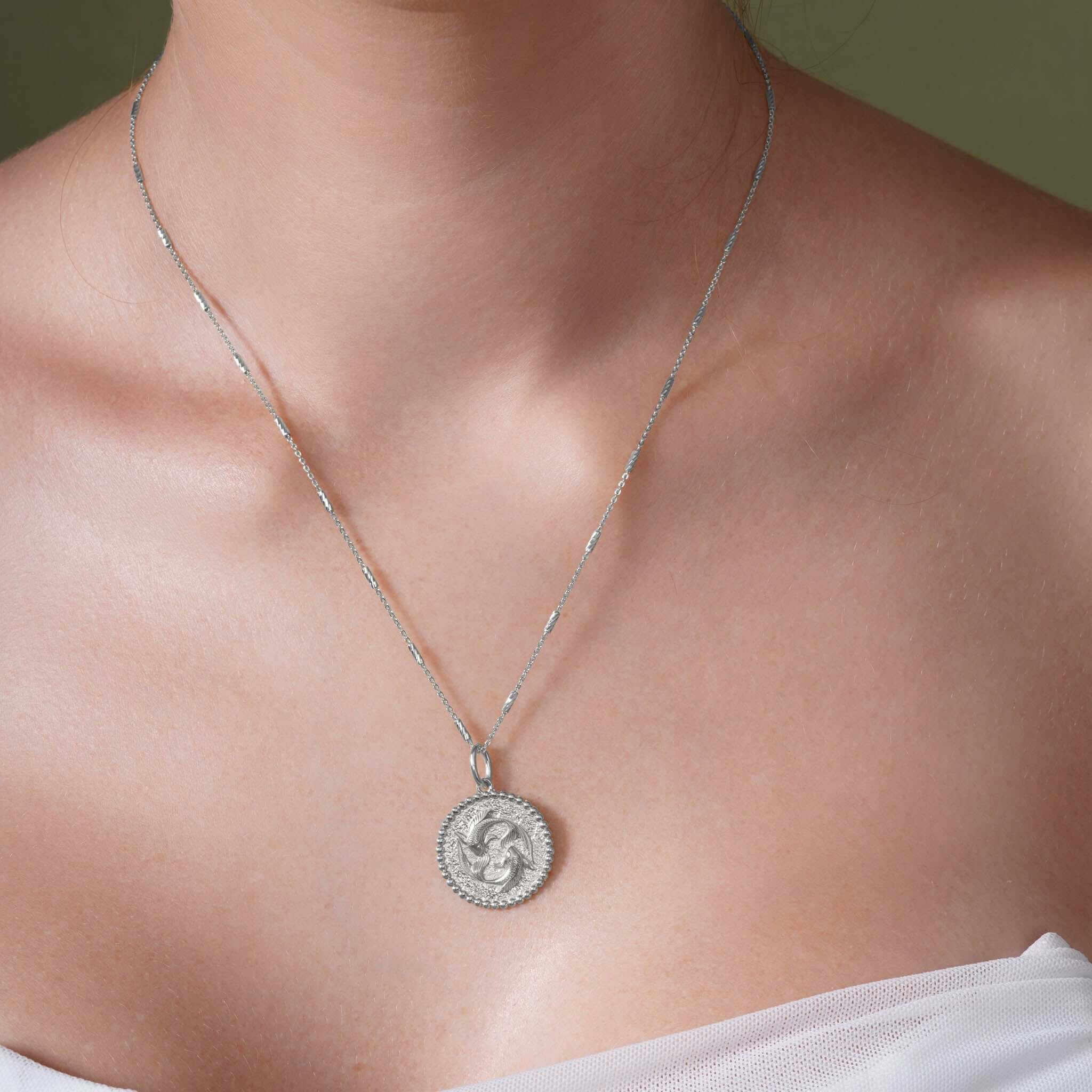 Zodiac Necklace featuring a zodiac symbol on a silver medallion with a delicate bar chain.