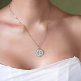 Close-up of a woman wearing a Zodiac Necklace featuring a circular medallion with intricate design.