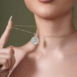 Close-up of a woman wearing a Zodiac Necklace, featuring a medallion with a zodiac symbol on a sleek chain.