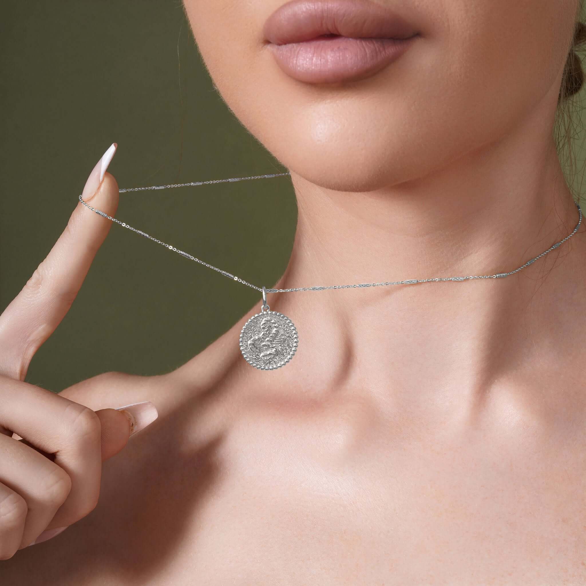 Model showcasing Zodiac Necklace with a textured medallion pendant on a sleek bar chain.