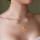 Zodiac Necklace showcasing a gold medallion on a sleek chain worn around the neckline.