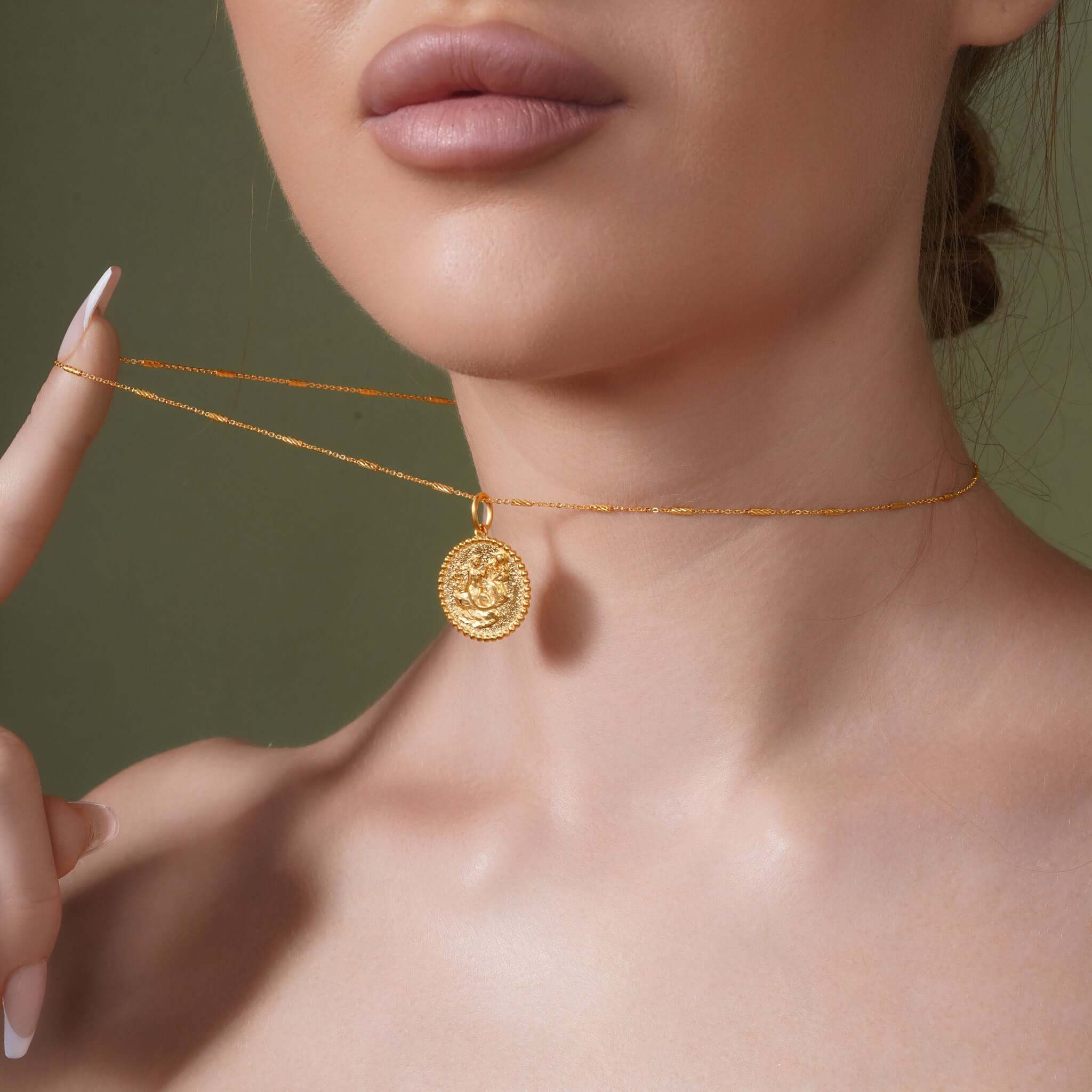Zodiac Necklace displayed on a model, showcasing a gold medallion pendant and sleek bar chain.