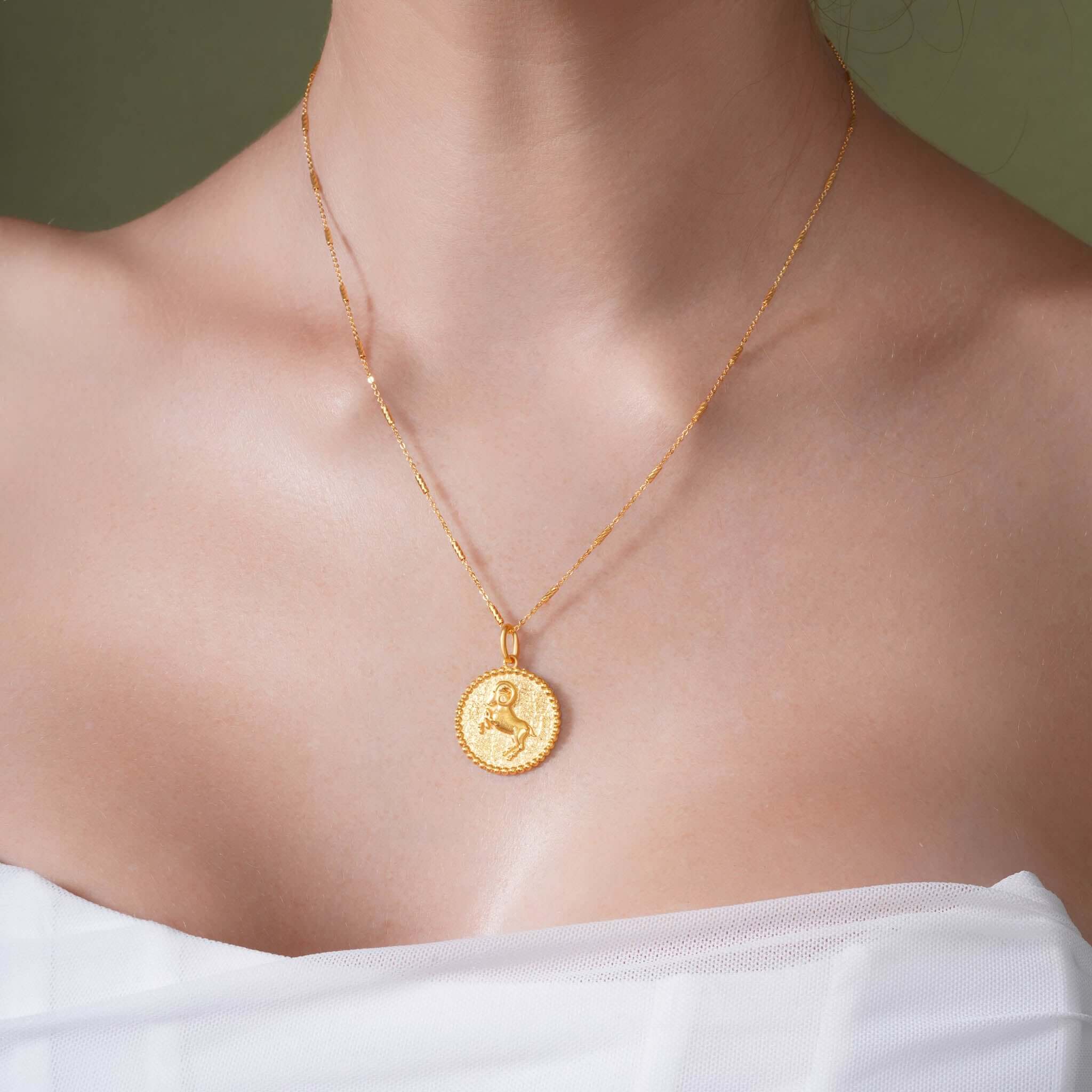 Zodiac Necklace featuring a gold medallion pendant showcasing a zodiac symbol, worn on a delicate chain.