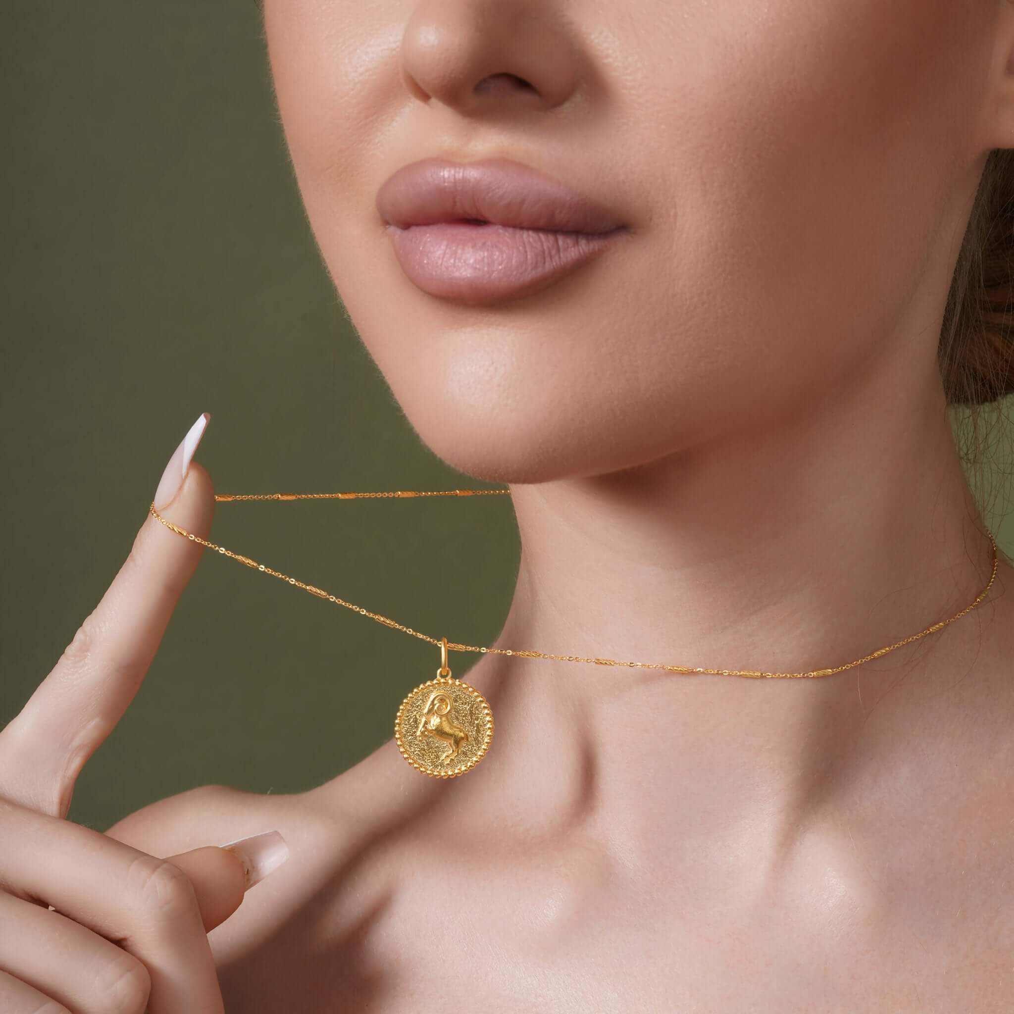 Zodiac Necklace featuring gold medallion with zodiac symbol on sleek chain, worn elegantly near the neckline.