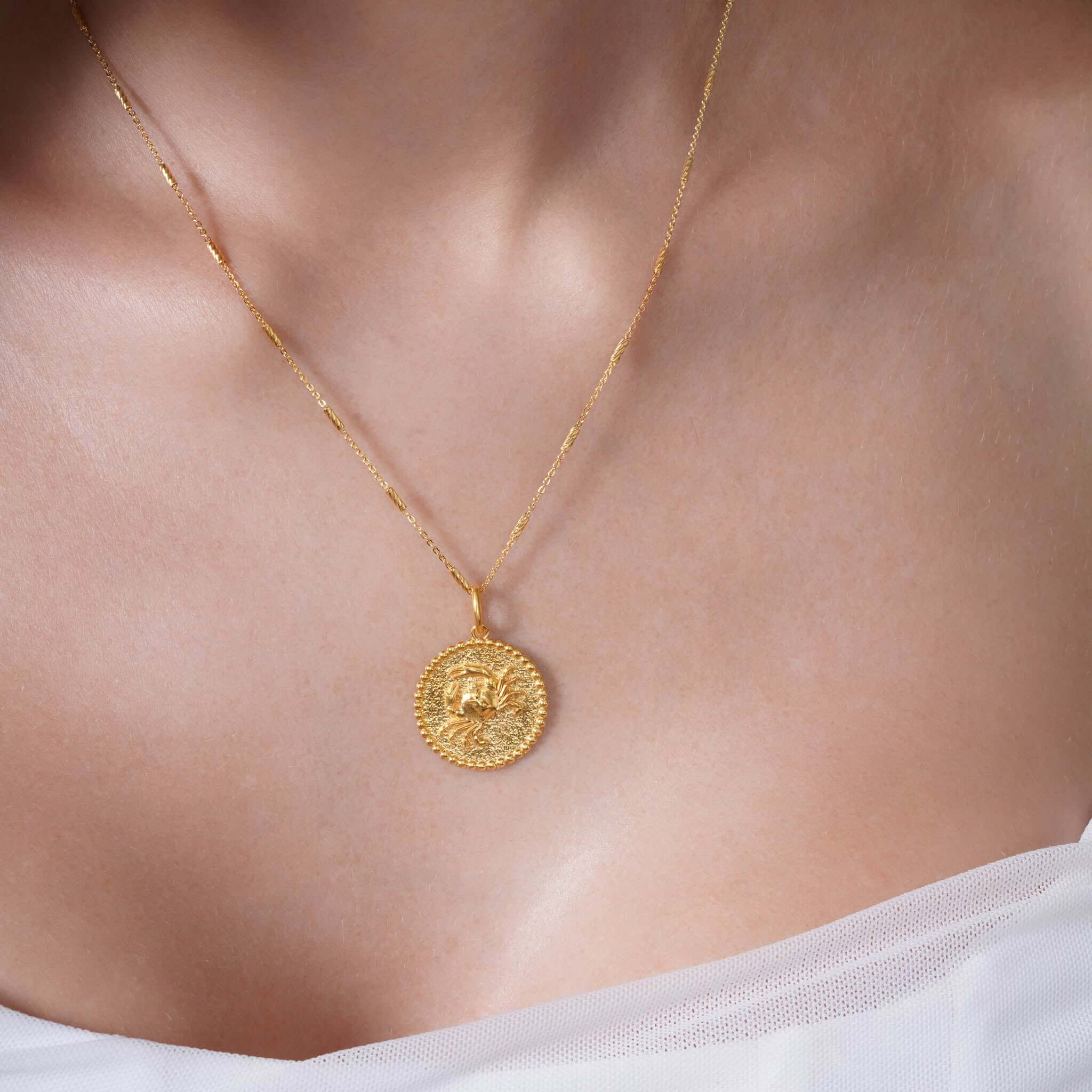 Zodiac Necklace featuring a gold medallion on a sleek chain, showcasing a zodiac symbol at the center.