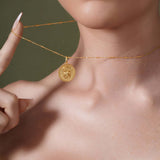 Model wearing a Zodiac Necklace showcasing a gold medallion with zodiac symbol on a delicate chain.