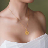 Zodiac Necklace featuring a gold medallion pendant on a sleek bar chain worn elegantly.