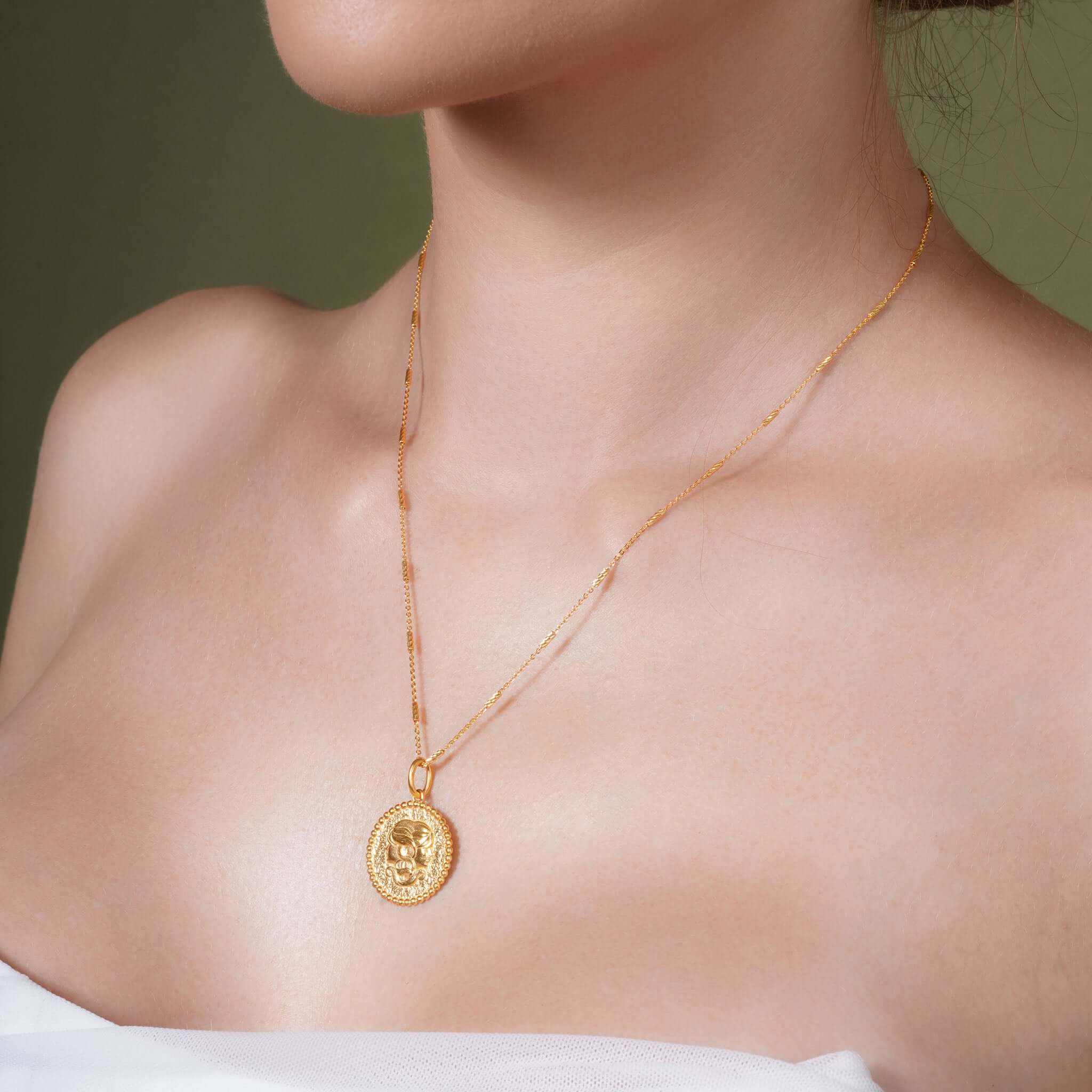 Zodiac Necklace showcasing a gold medallion pendant on a sleek chain worn by a model.