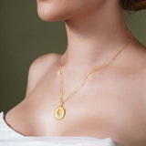 Zodiac Necklace worn by a model, featuring a gold medallion with zodiac symbol on a sleek chain.