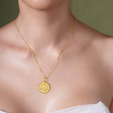 Model wearing a gold Zodiac Necklace featuring the Libra symbol on a delicate chain.