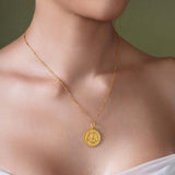 Zodiac Necklace showcasing a gold medallion with a textured background, worn on a neckline.