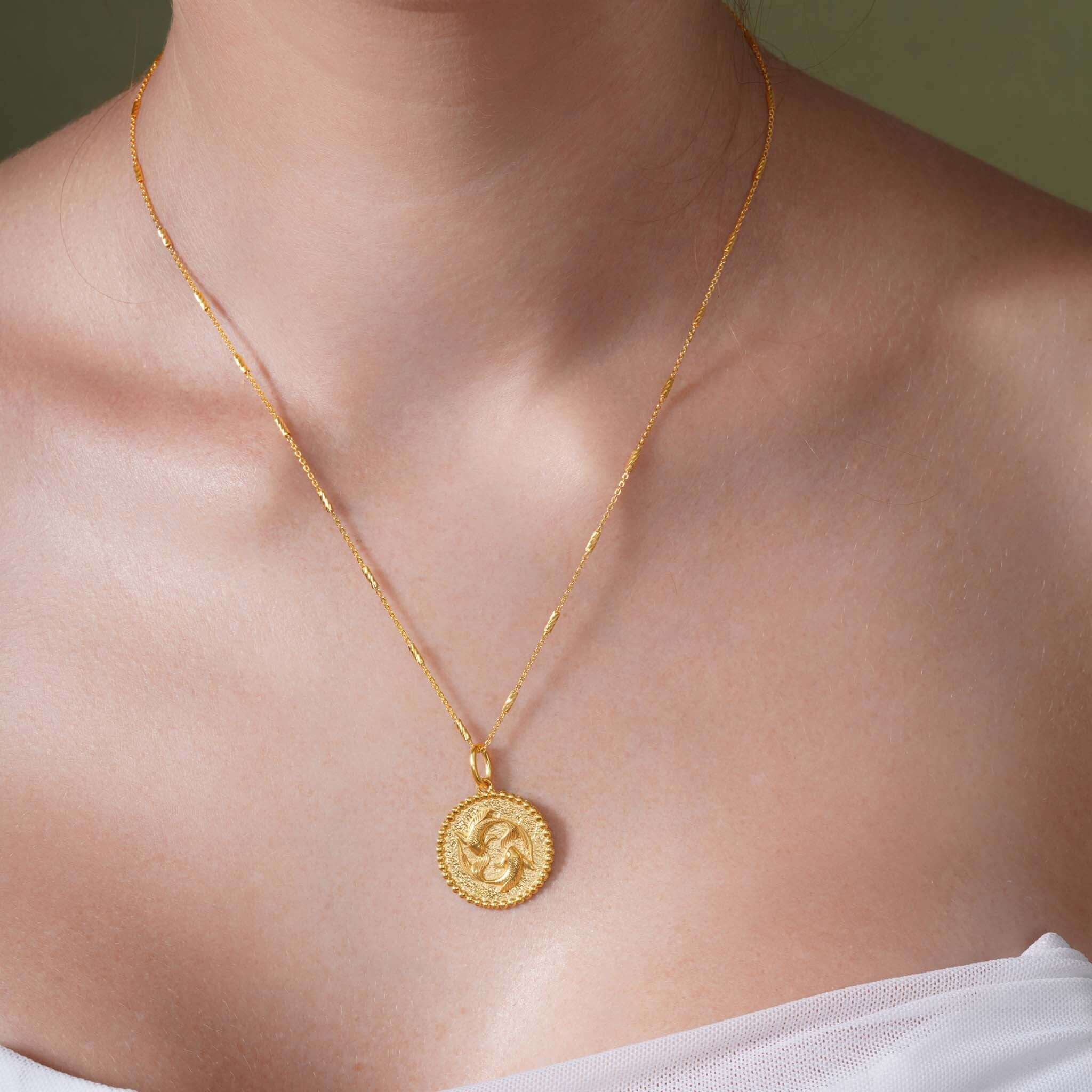 Zodiac Necklace featuring a gold medallion with zodiac symbol, suspended on a sleek chain, perfect for layering.