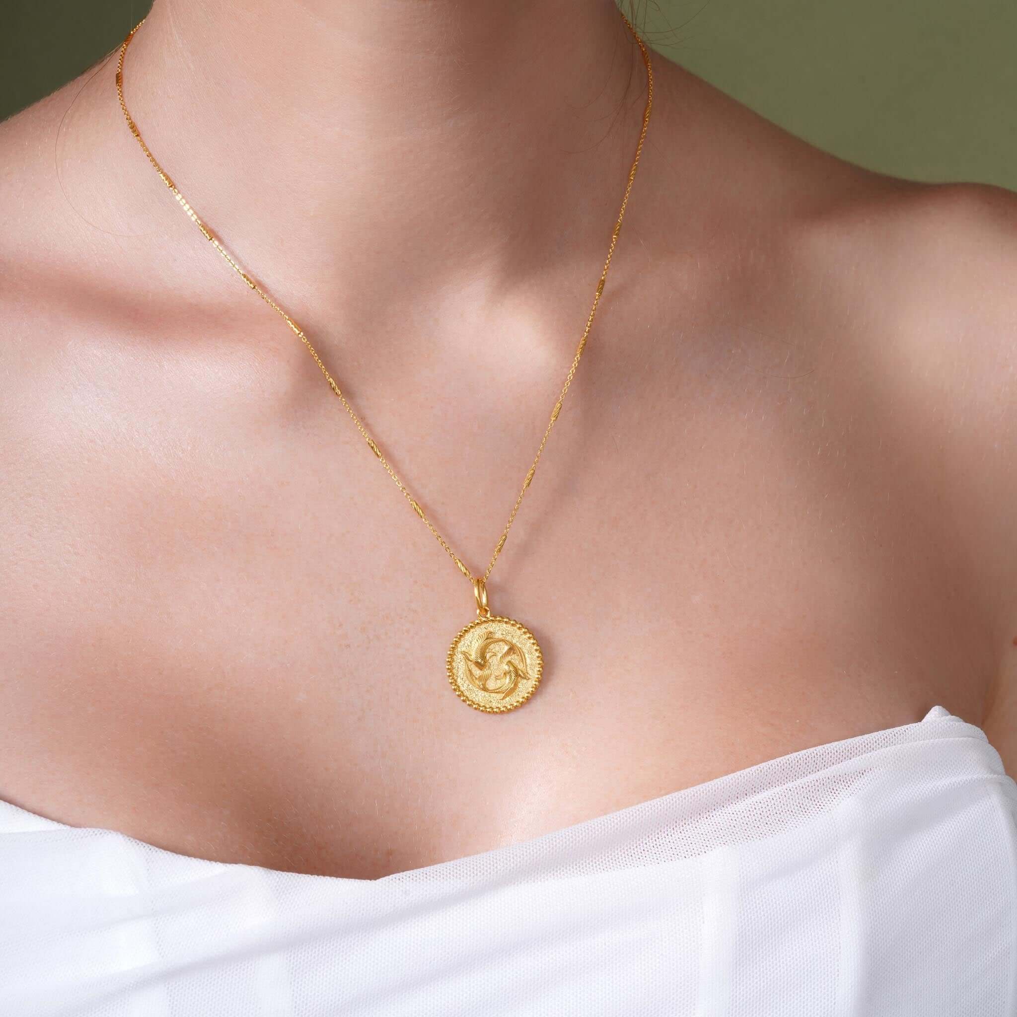 Zodiac Necklace featuring a gold medallion with a zodiac symbol, suspended from a sleek bar chain.