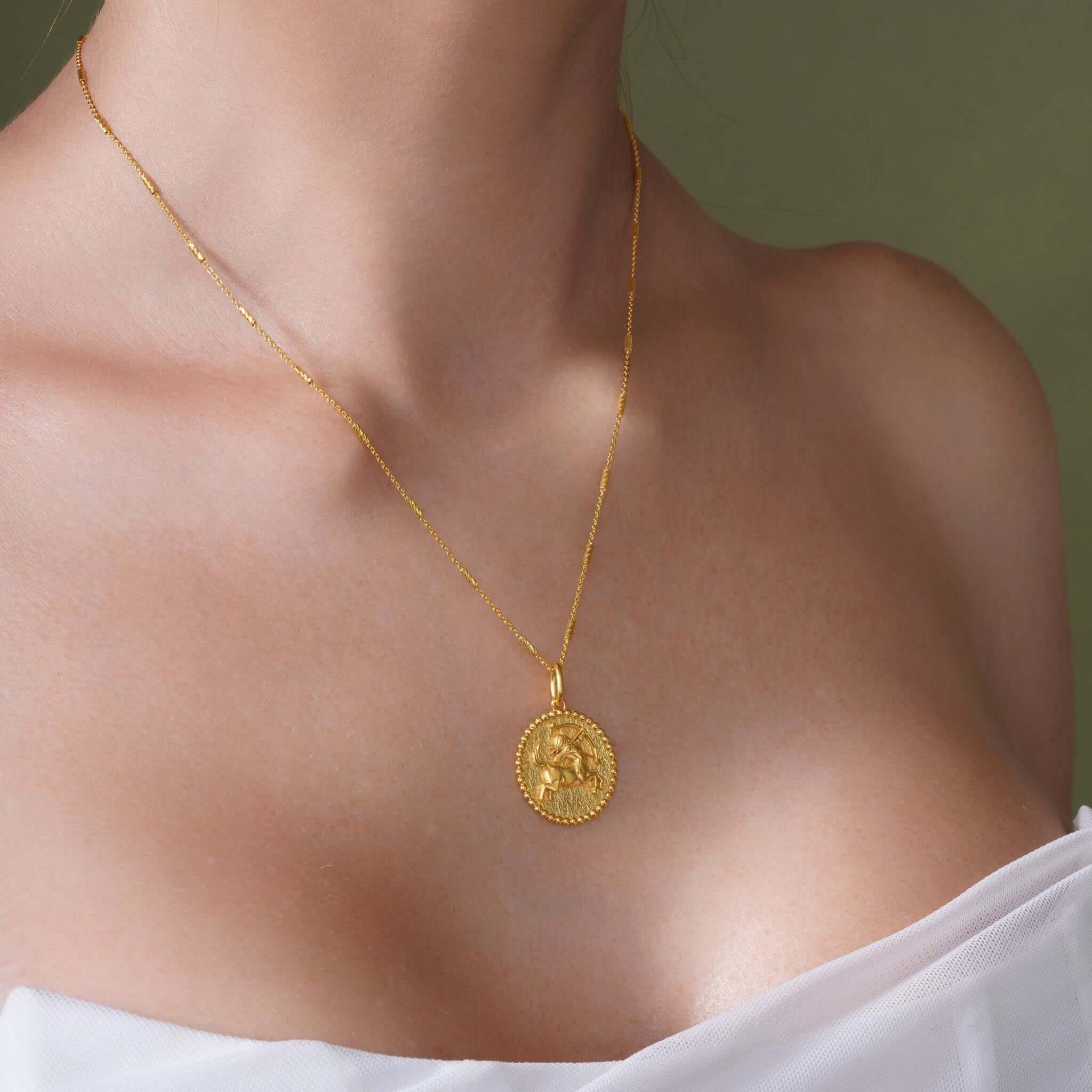 Gold Zodiac Necklace featuring a medallion with zodiac symbol, worn elegantly on a sleek chain, perfect for layering.