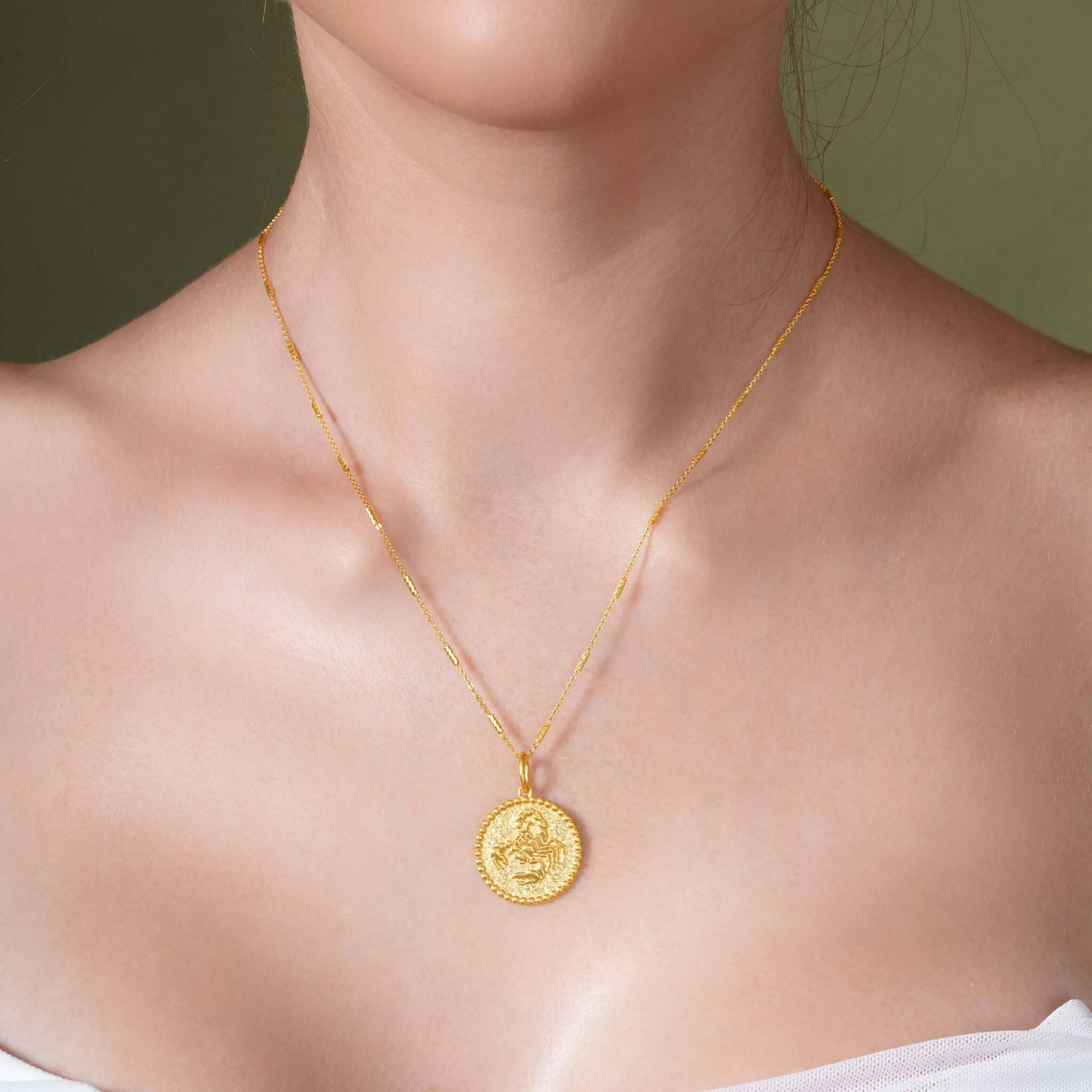 Zodiac Necklace featuring a gold medallion on a sleek chain, showcasing a zodiac symbol with a textured background.