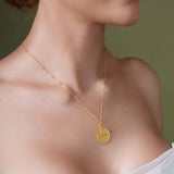 Close-up of a woman wearing a gold Zodiac Necklace with a medallion pendant.