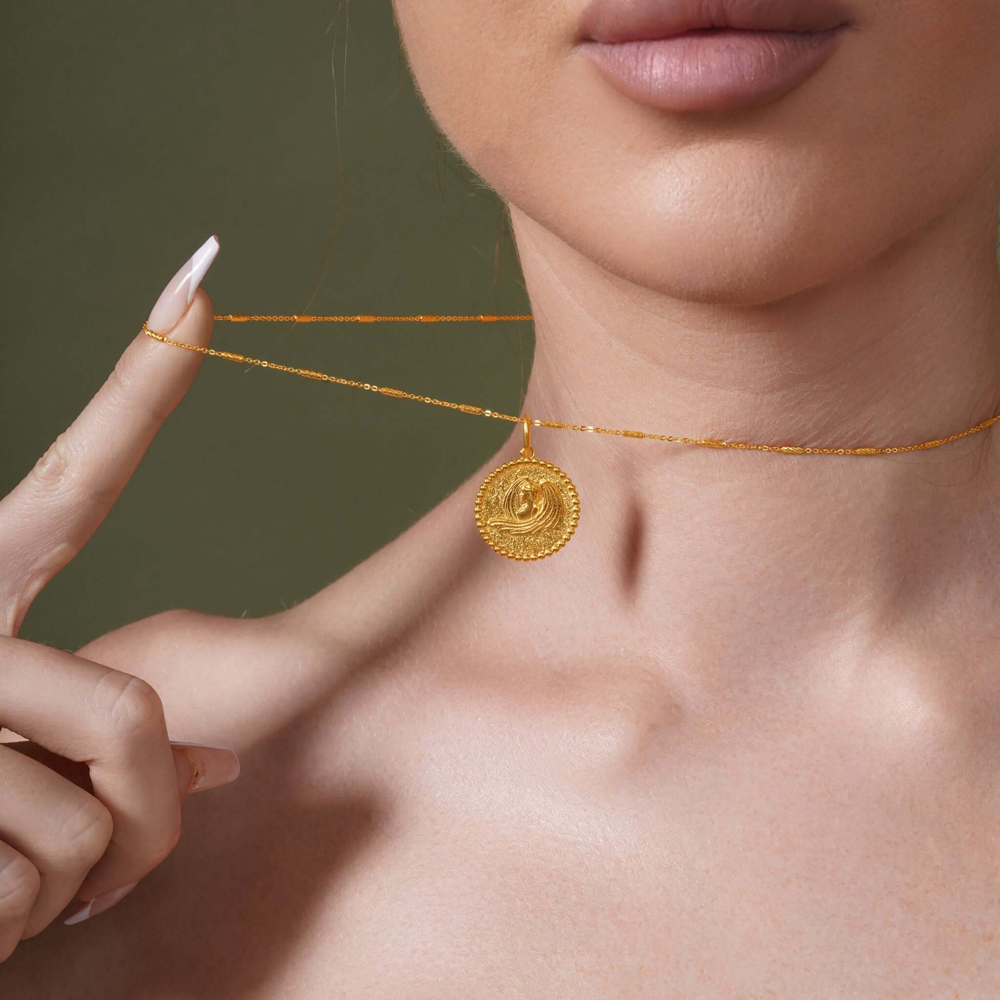 Zodiac Necklace worn close to neckline, showcasing zodiac symbol medallion with textured background.