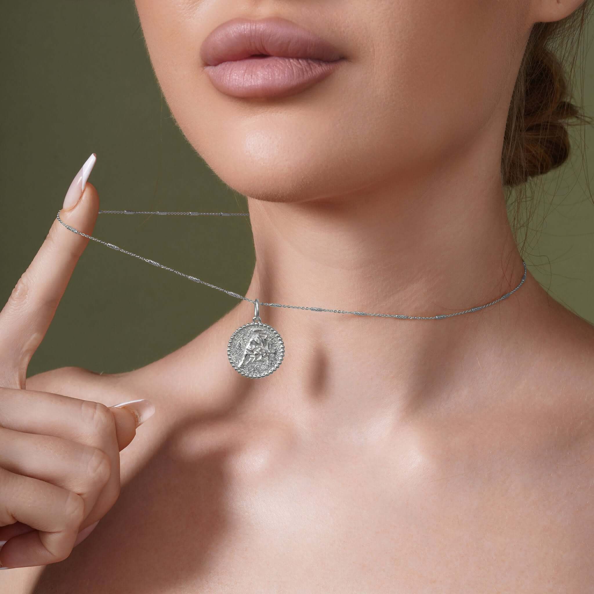 Close-up of a woman wearing a Zodiac Necklace featuring a detailed zodiac symbol pendant on a sleek chain.