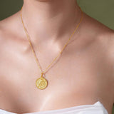 Zodiac Necklace worn on model, featuring a gold medallion with zodiac symbol on a delicate chain.