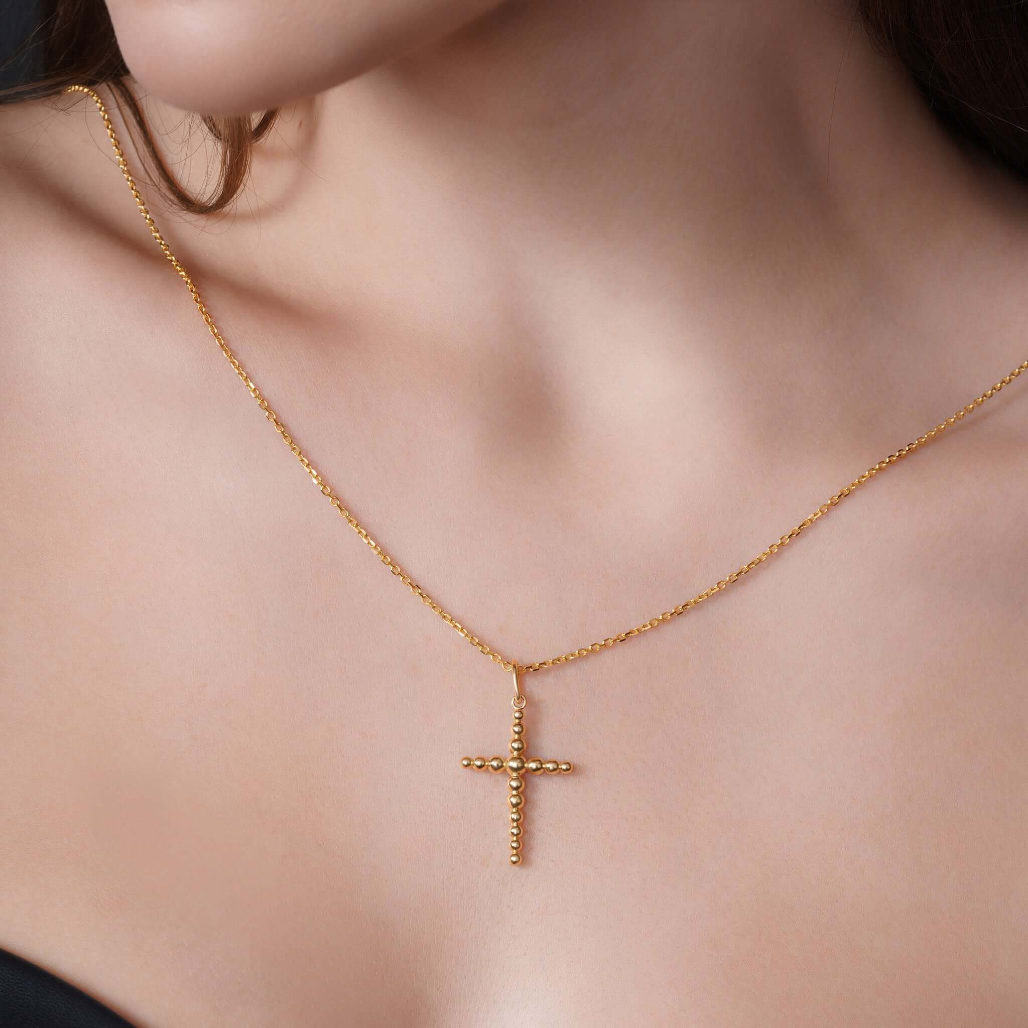 Vermeil Beaded Cross Necklace displayed on a model, featuring a polished beaded cross on a 16-18 inch adjustable chain.