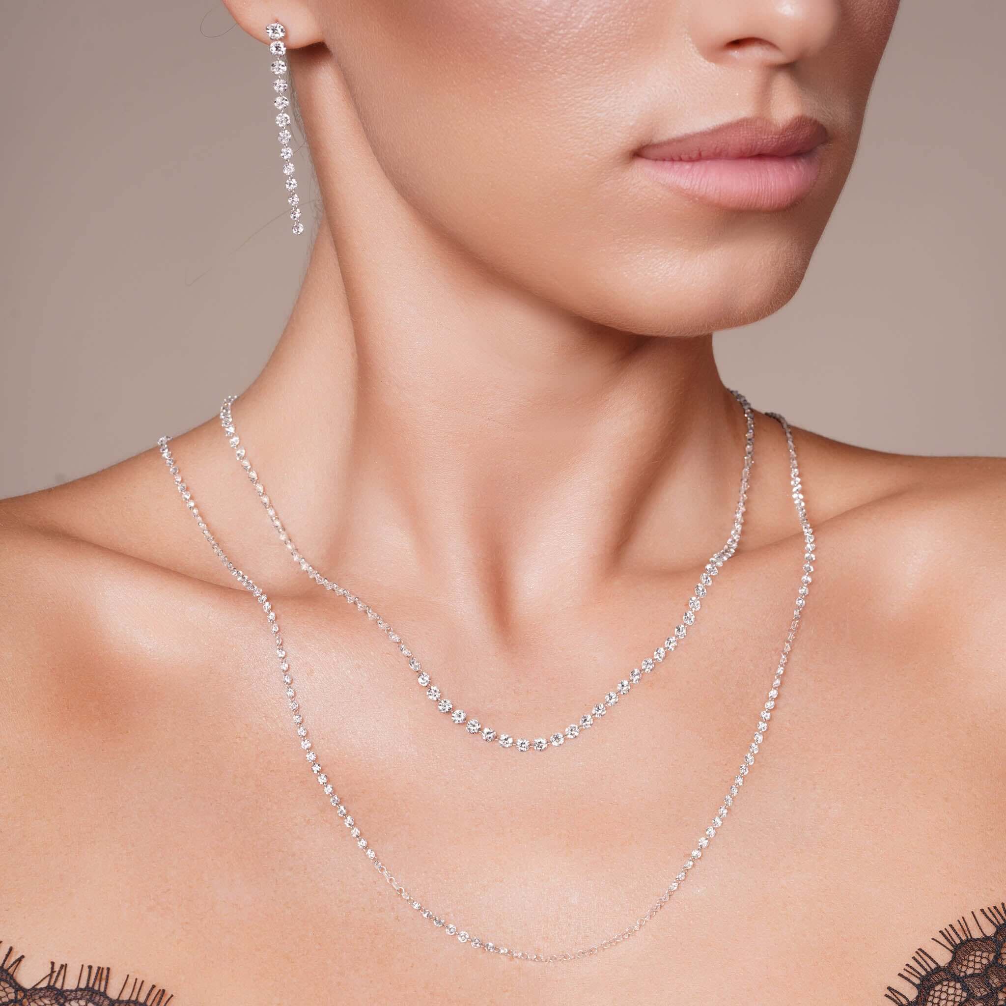 Model wearing a 24.8 Carat Floating Lab Diamond Necklace layered with elegant earrings.