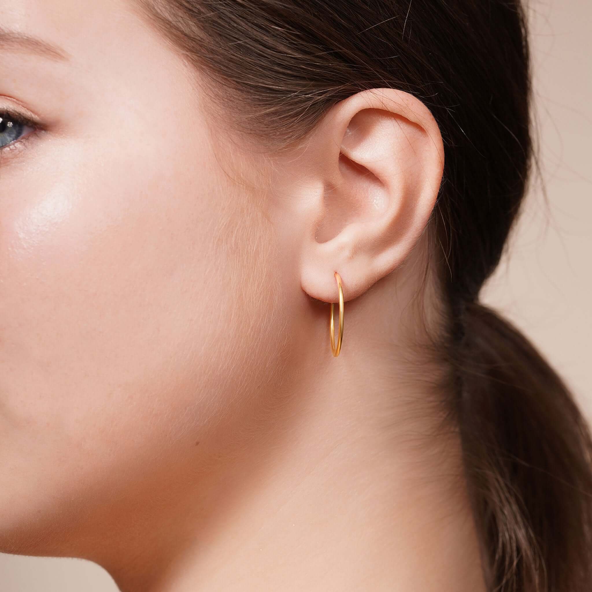 Model wearing Gold Endless Hoop Earrings showcasing their elegant design and high-quality gold finish.