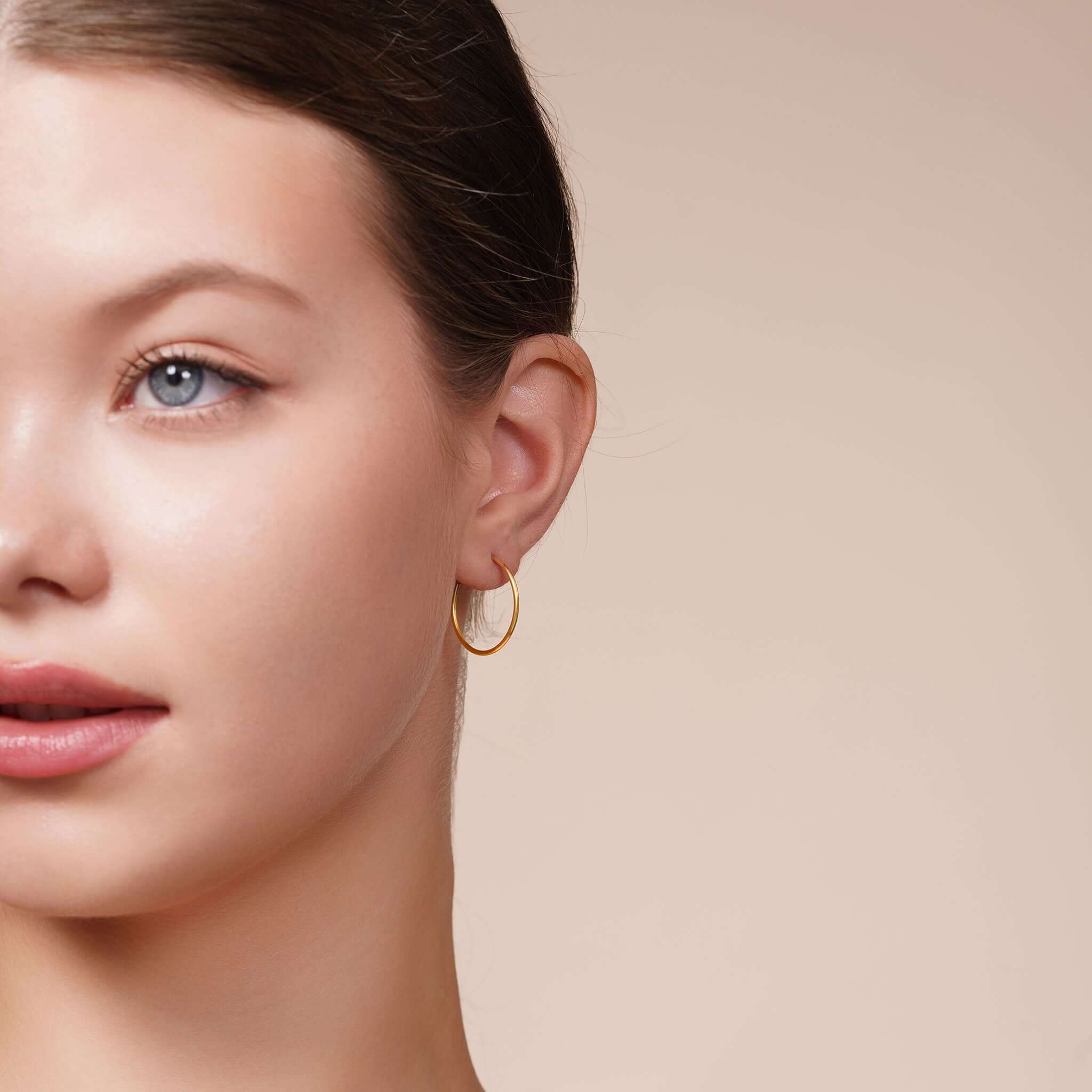 Model wearing Gold Endless Hoop Earrings showcasing their timeless design and elegant shine.
