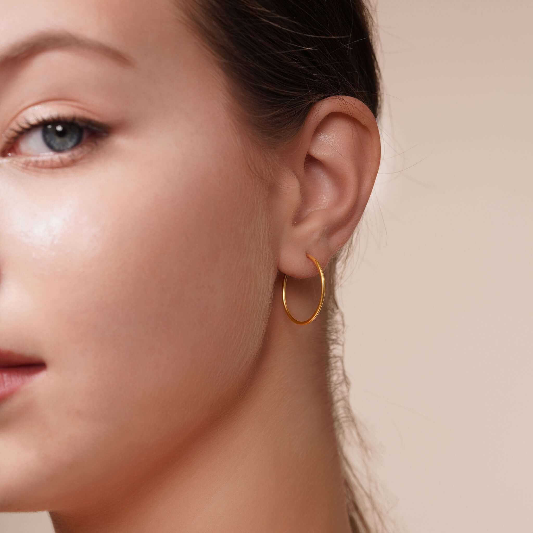 Model wearing Gold Endless Hoop Earrings, showcasing their elegance and timeless design.