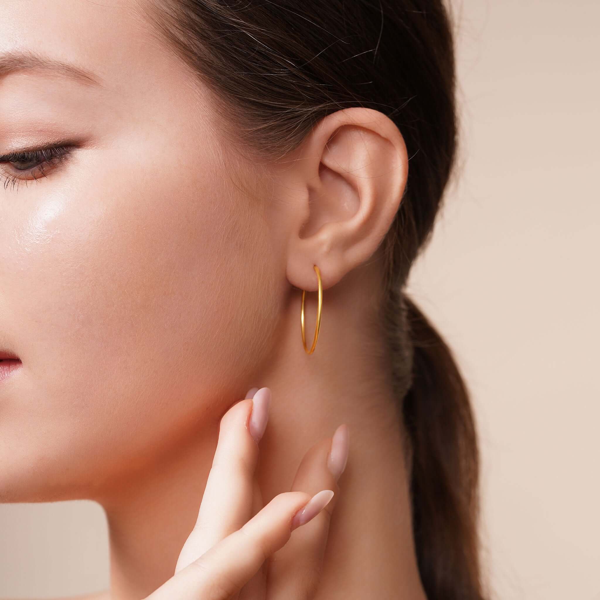 Model wearing Gold Endless Hoop Earrings, showcasing their timeless design and elegance.