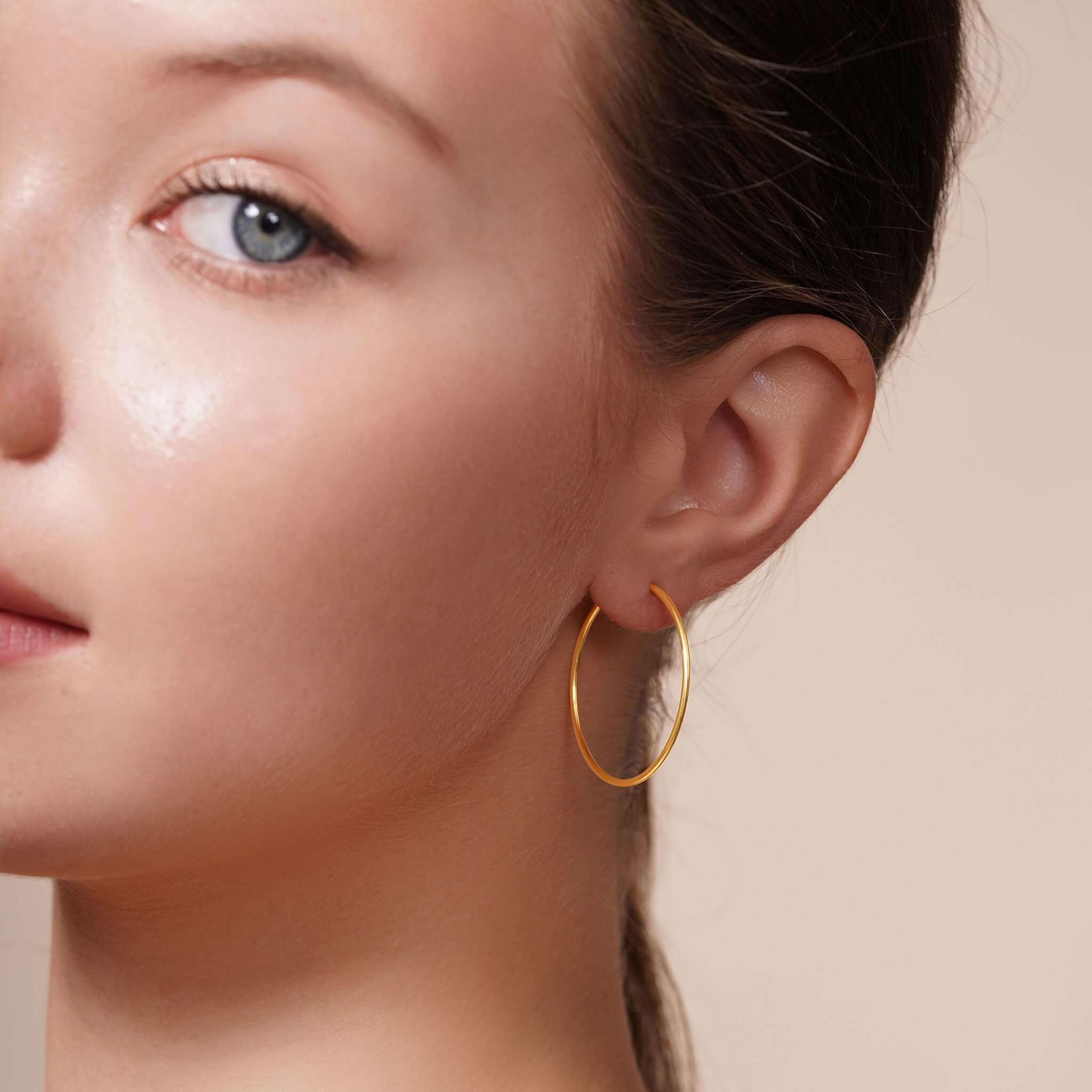 Close-up of a woman wearing Gold Endless Hoop Earrings, showcasing their elegant and timeless design.