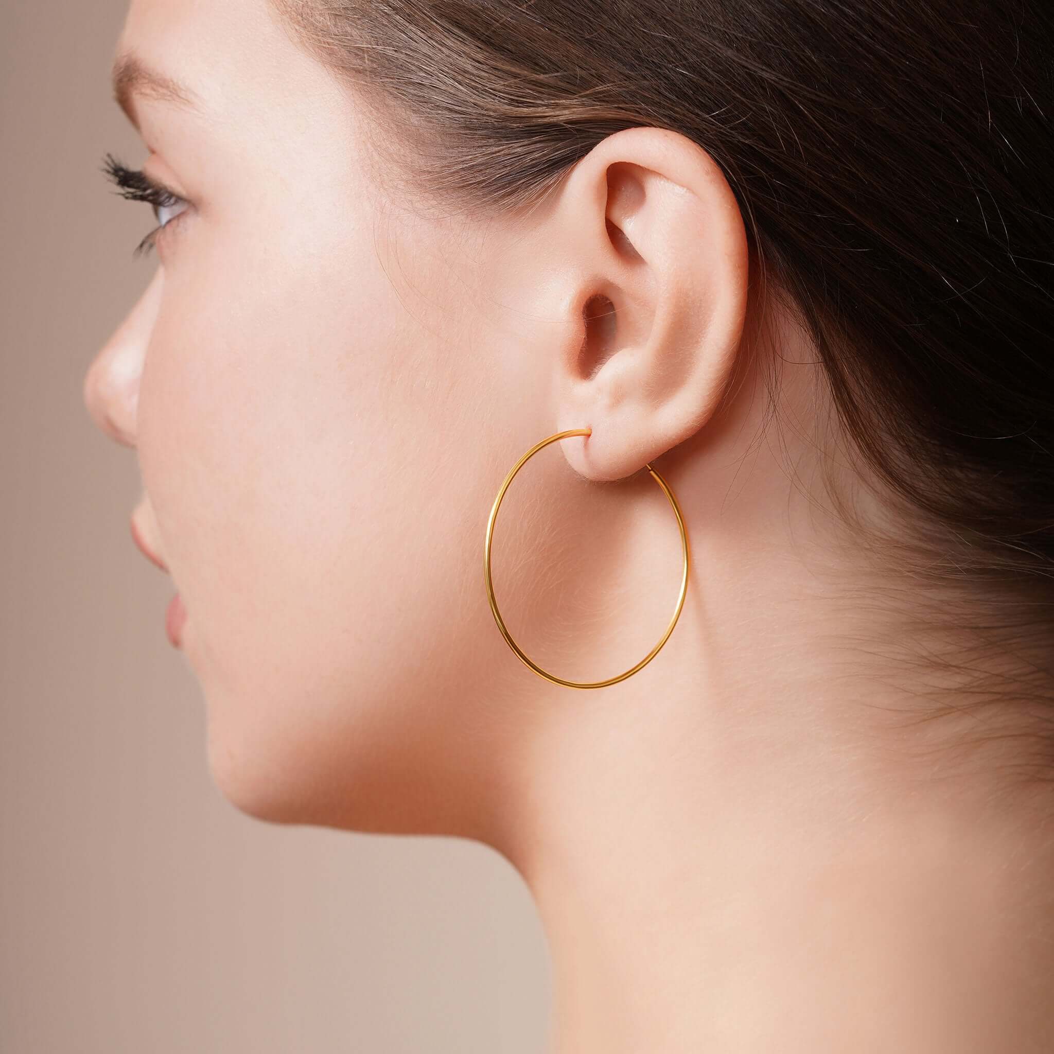 Model wearing Gold Endless Hoop Earrings, showcasing their elegant design and seamless look.