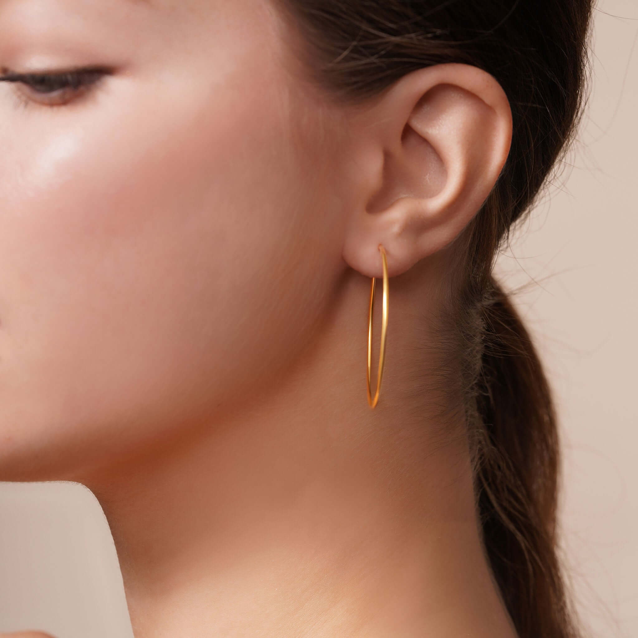 Gold Endless Hoop Earrings worn by a model showcasing their sleek and elegant design.