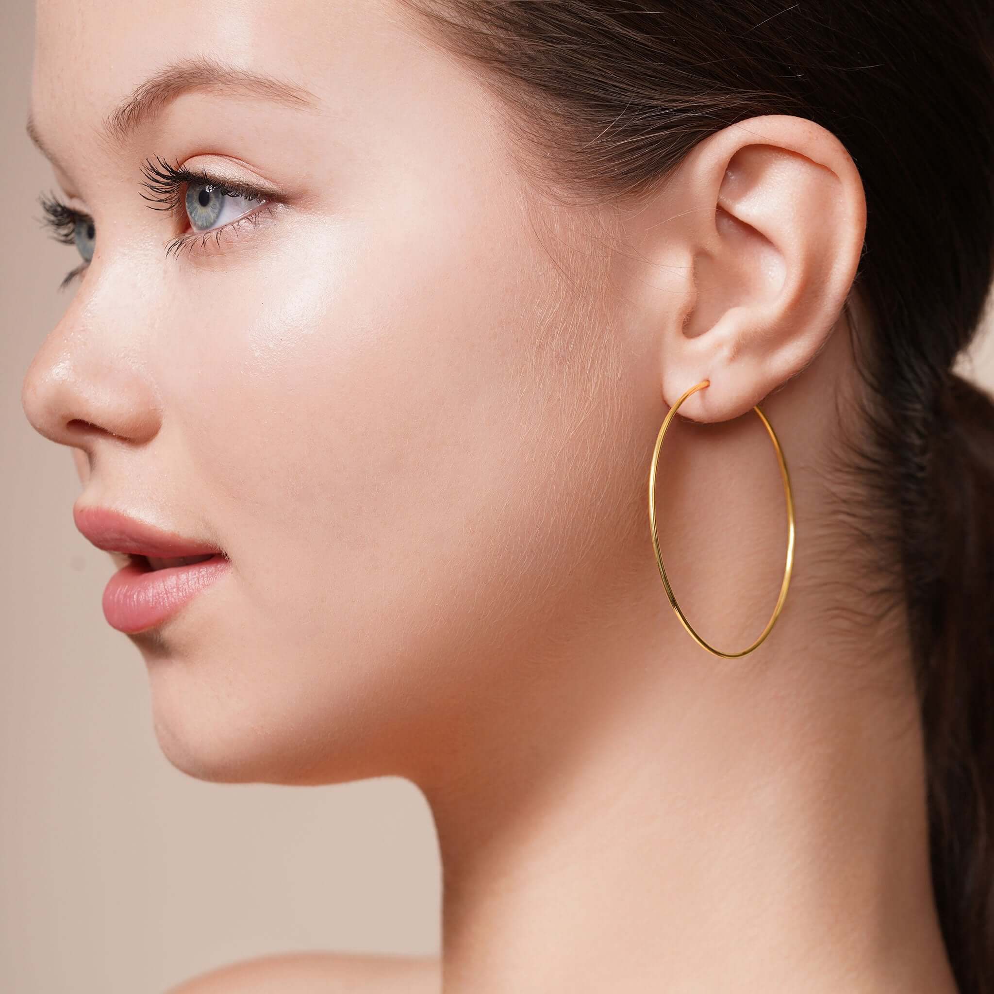 Model wearing Gold Endless Hoop Earrings showcasing elegant design and seamless look.