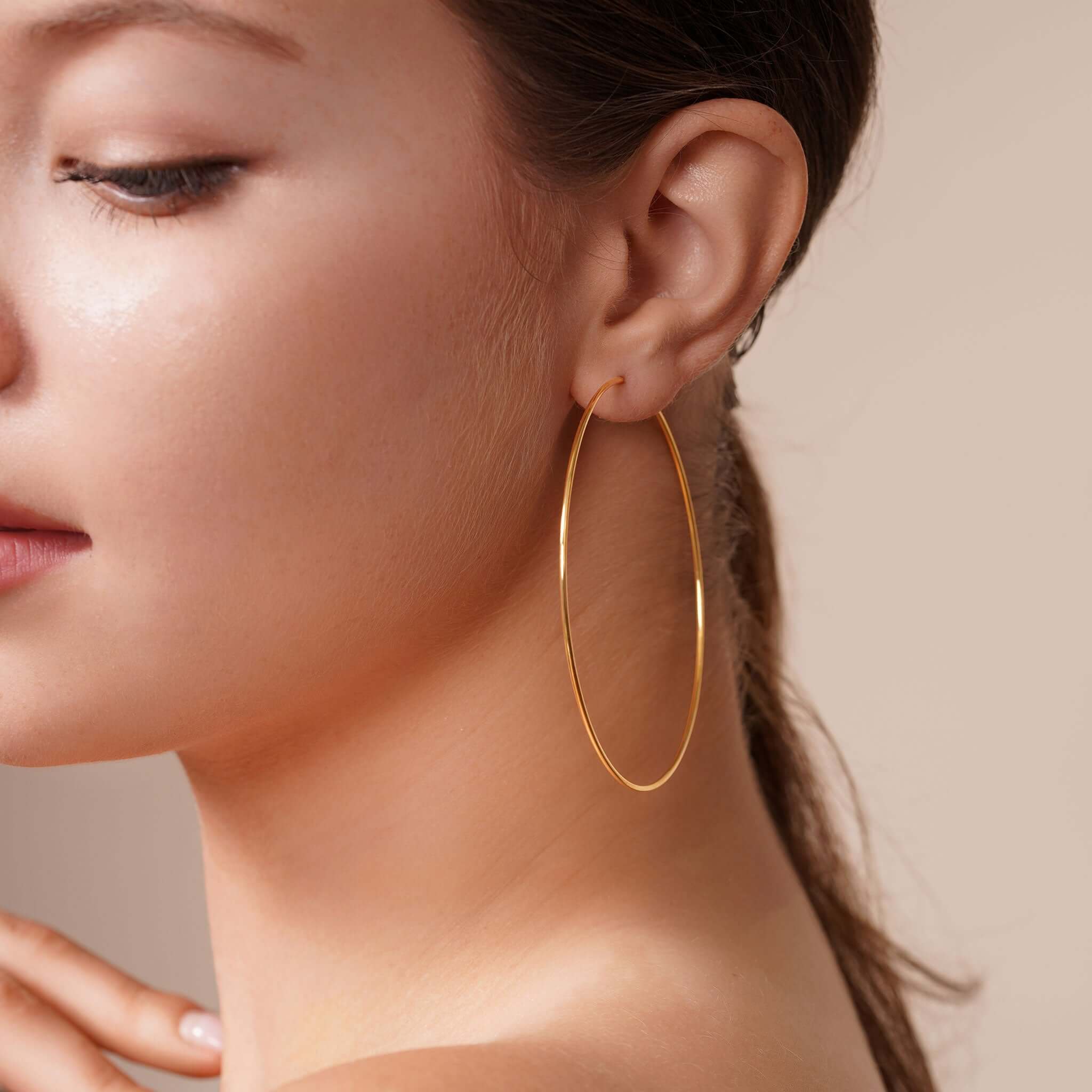 Model showcasing Gold Endless Hoop Earrings in a close-up profile for elegant style.