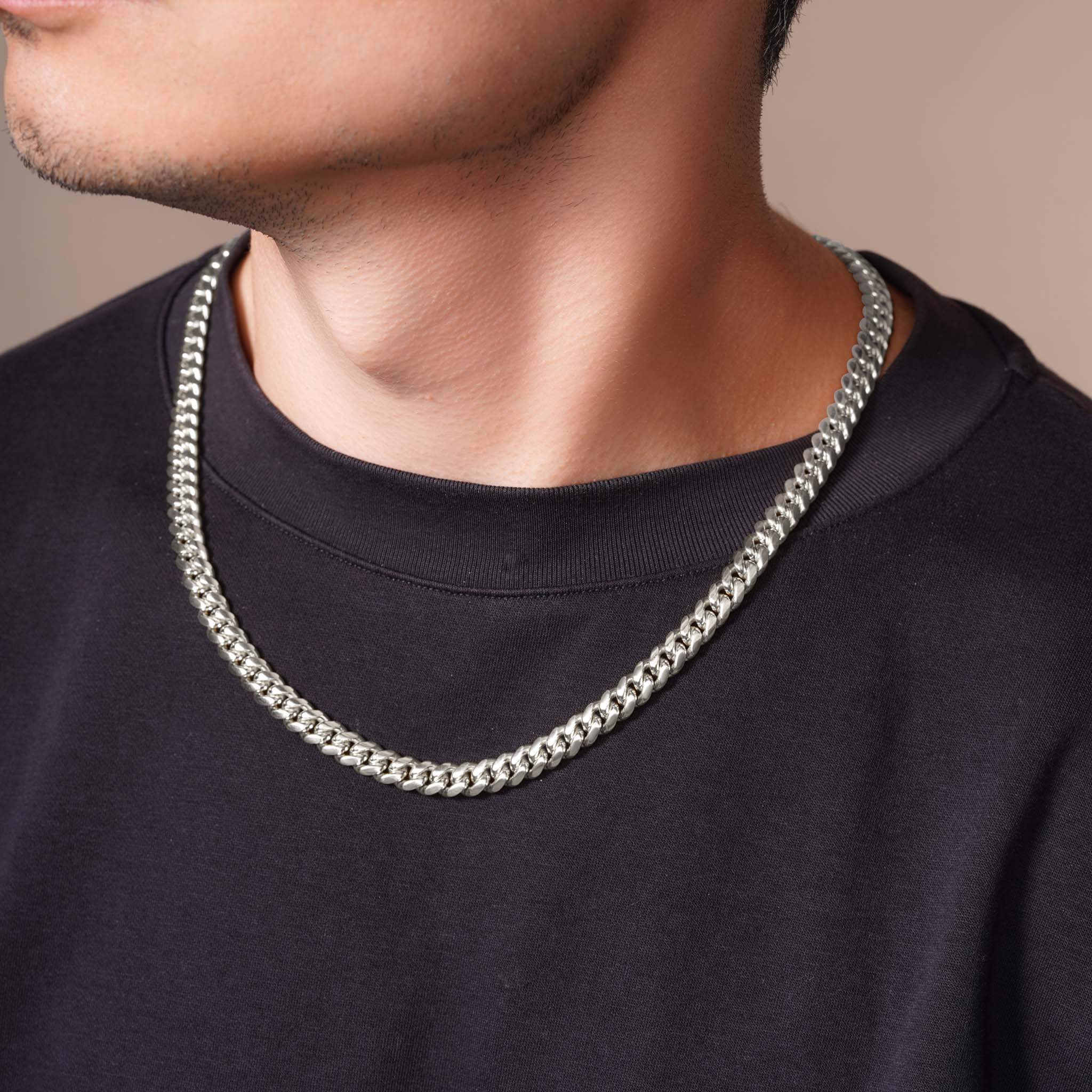 Men's White Gold Miami Cuban Chain worn by a man, highlighting its chunky and heavy design.